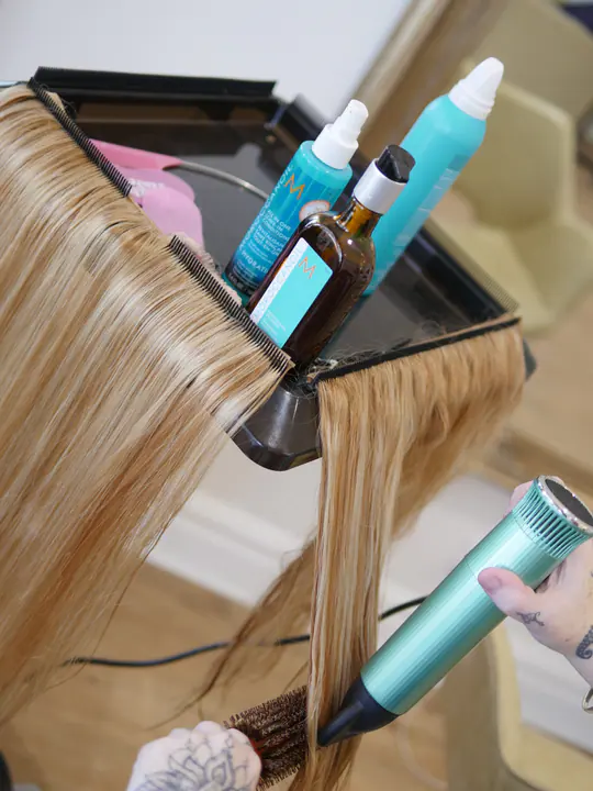 Blonde extensions being blow-dried and finished in the studio